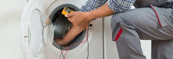 Dryer repair technician inspecting and repairing a clothes dryer in Boca Raton, FL