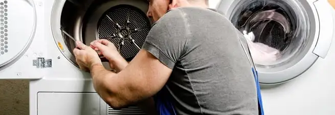 Dryer repair technician fixing a clothes dryer drum in Boca Raton, FL
