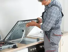 Appliance repair technician installing a built-in cooktop in Boca Raton, FL