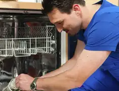 Dishwasher repair technician inspecting and servicing an open dishwasher in Boca Raton, FL