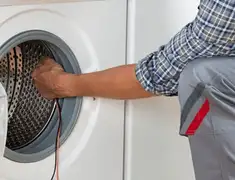 Dryer repair technician diagnosing and servicing a clothes dryer in Boca Raton, FL
