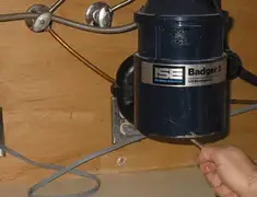 Garbage disposal repair technician tightening the mounting ring under a sink in Boca Raton, FL