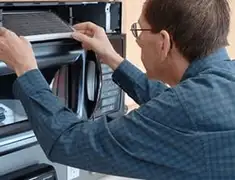 Appliance repair technician replacing a microwave vent filter in Boca Raton, FL