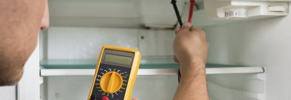 Refrigerator repair technician testing electrical components with a multimeter in Boca Raton, FL