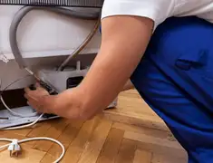 Appliance repair technician fixing refrigerator water line and connections in Boca Raton, FL