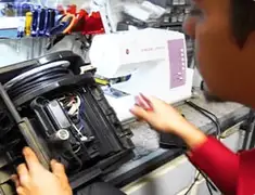 Vacuum repair technician servicing internal components on a workbench in Boca Raton, FL