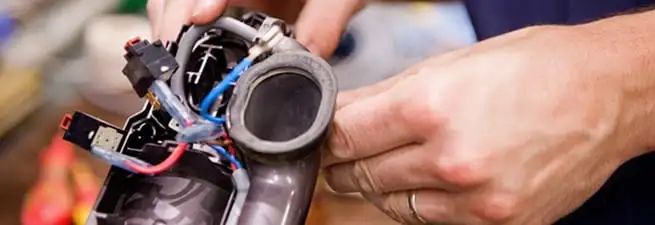 Vacuum repair technician reconnecting wiring and components in Boca Raton, FL