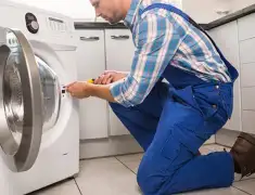 Washing machine repair technician servicing a front-load washer in Boca Raton, FL