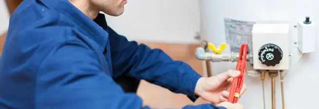 Water heater repair technician adjusting the temperature control and gas valve in Boca Raton, FL